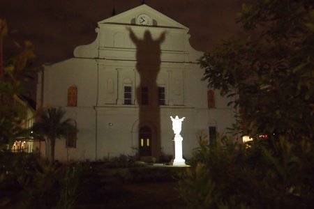 De schaduw van Jezus word op de kerkmuur geprojecteerd